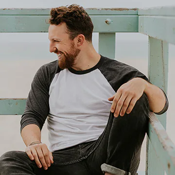 Young man sitting on a beach deck