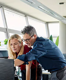 Office coworkers looking at a computer monitor